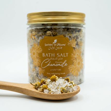 Illustrative close-up of coarse salt crystals and dried chamomile flowers