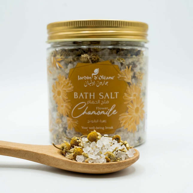 Illustrative close-up of coarse salt crystals and dried chamomile flowers